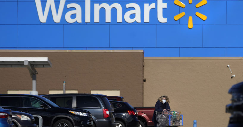 A woman wheels a cart with her purchases out of a Walmart store, November 18, 2020, in Derry, New Hampshire.