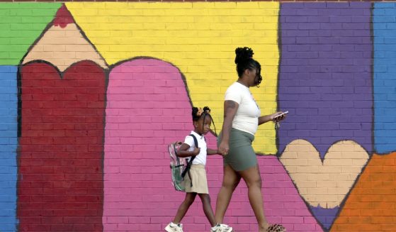 Bria Gibbs brings her daughter Tai'la Harris, 4, into Columbia Elementary school for the first day of classes for St. Louis Public Schools on Monday. Gibbs drove her daughter to school.