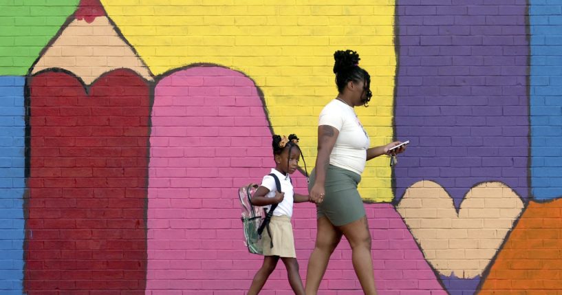 Bria Gibbs brings her daughter Tai'la Harris, 4, into Columbia Elementary school for the first day of classes for St. Louis Public Schools on Monday. Gibbs drove her daughter to school.