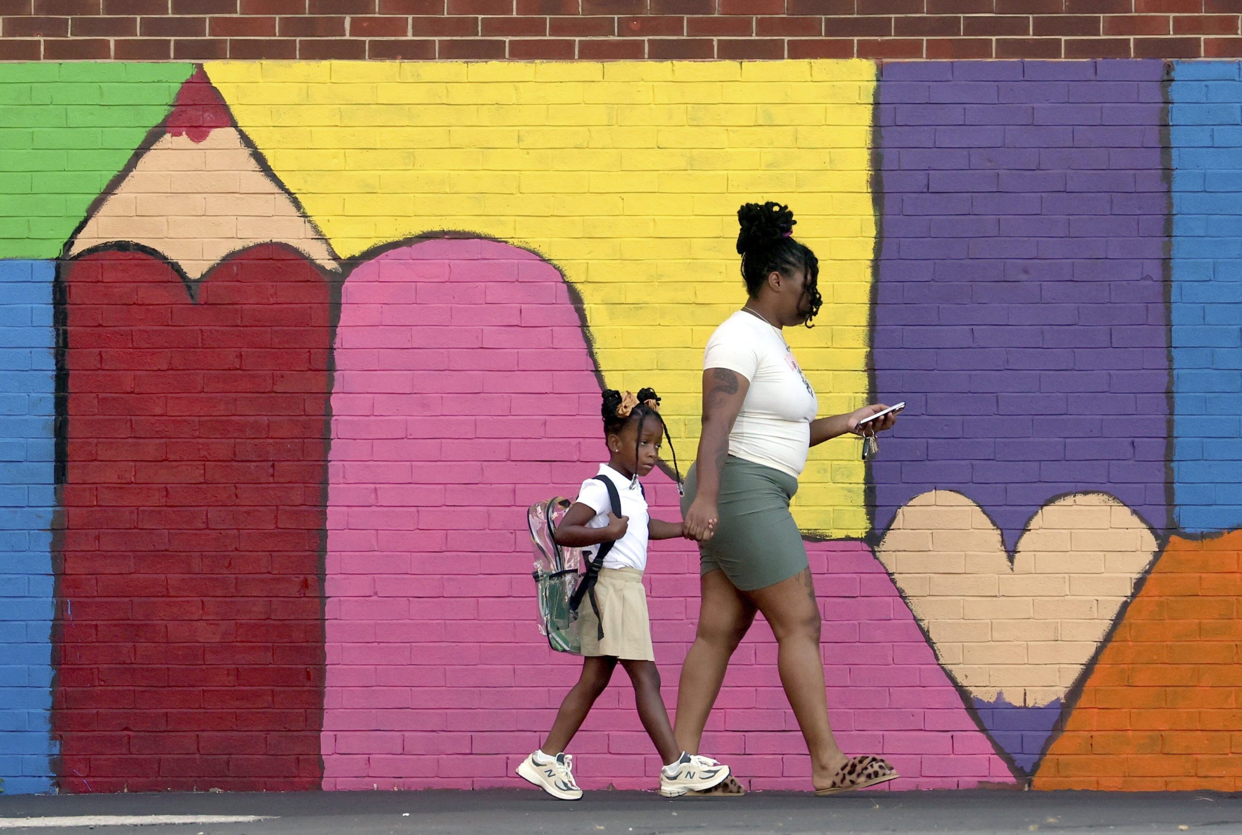 Bria Gibbs brings her daughter Tai'la Harris, 4, into Columbia Elementary school for the first day of classes for St. Louis Public Schools on Monday. Gibbs drove her daughter to school.