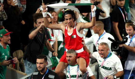 Imane Khelif of Team Algeria celebrates winning the gold medal with Team Algeria Coaches Mohamed Chaoua and Mohamed Al-Shawa after the Boxing Women's 66kg Final match against Liu Yang of Team China on day fourteen of the Olympic Games Paris 2024 at Roland Garros on August 9, 2024 in Paris, France.