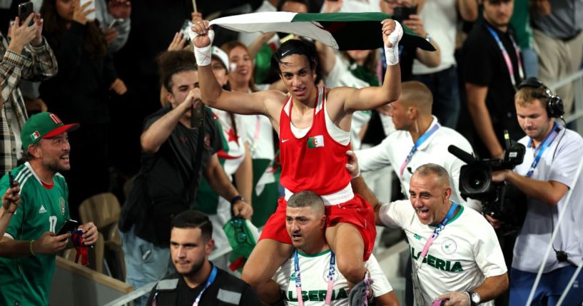 Imane Khelif of Team Algeria celebrates winning the gold medal with Team Algeria Coaches Mohamed Chaoua and Mohamed Al-Shawa after the Boxing Women's 66kg Final match against Liu Yang of Team China on day fourteen of the Olympic Games Paris 2024 at Roland Garros on Aug. 9 in Paris, France.