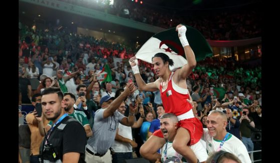 Imane Khelif of Team Algeria celebrates winning the gold medal with Team Algeria Coaches Mohamed Chaoua and Mohamed Al-Shawa after the Boxing Women's 66kg Final match against Liu Yang of Team China on day fourteen of the Olympic Games Paris 2024 at Roland Garros on August 9, 2024 in Paris, France.