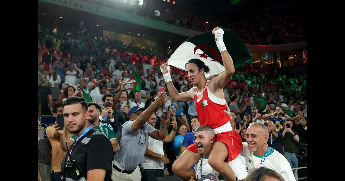 Imane Khelif of Team Algeria celebrates winning the gold medal with Team Algeria Coaches Mohamed Chaoua and Mohamed Al-Shawa after the Boxing Women's 66kg Final match against Liu Yang of Team China on day fourteen of the Olympic Games Paris 2024 at Roland Garros on August 9, 2024 in Paris, France.