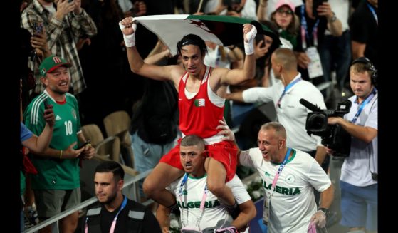 Imane Khelif of Team Algeria celebrates winning the gold medal with Team Algeria Coaches Mohamed Chaoua and Mohamed Al-Shawa after the Boxing Women's 66kg Final match against Liu Yang of Team China on day fourteen of the Olympic Games Paris 2024 at Roland Garros on August 9, 2024 in Paris, France.