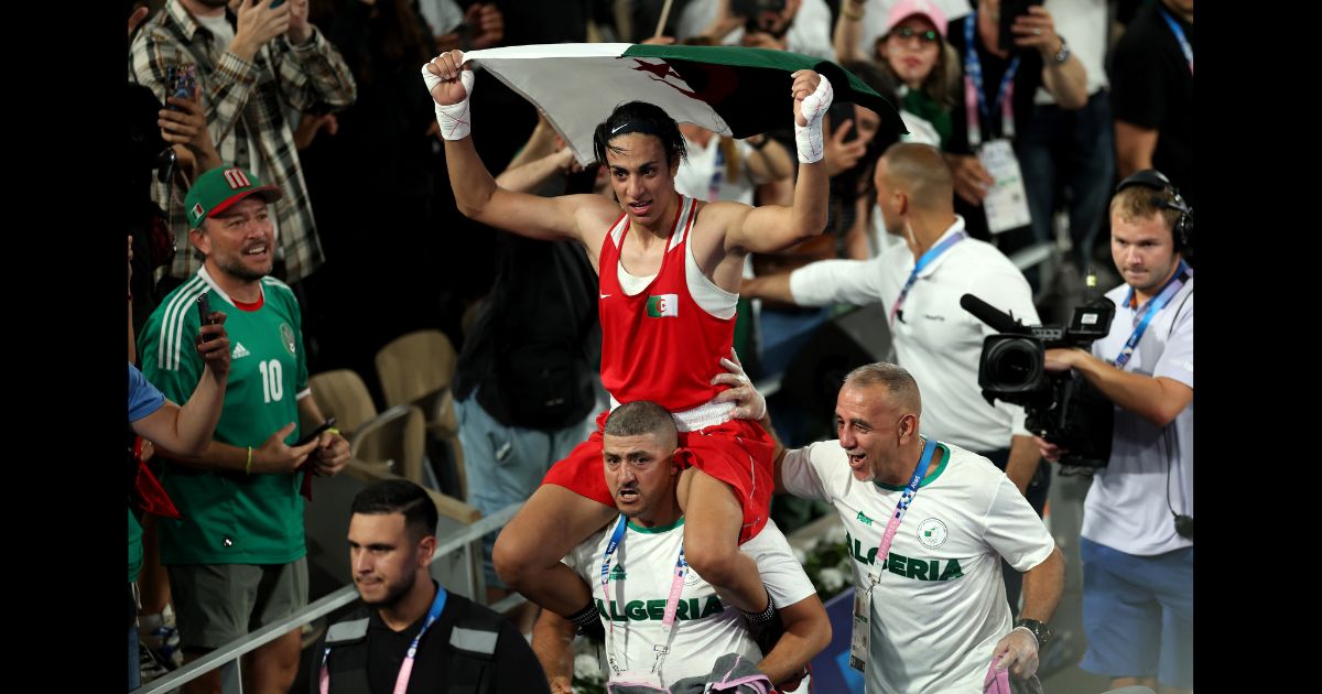 Imane Khelif of Team Algeria celebrates winning the gold medal with Team Algeria Coaches Mohamed Chaoua and Mohamed Al-Shawa after the Boxing Women's 66kg Final match against Liu Yang of Team China on day fourteen of the Olympic Games Paris 2024 at Roland Garros on August 9, 2024 in Paris, France.