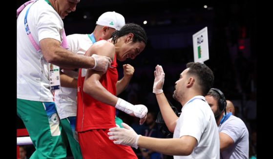 Imane Khelif of Team Algeria is assisted out of the ring by Mohamed Al-Shawa, Coach of Team Hungary after the Women's 66kg Quarter-final round match on day eight of the Olympic Games Paris 2024 at North Paris Arena on August 3, 2024 in Paris, France.