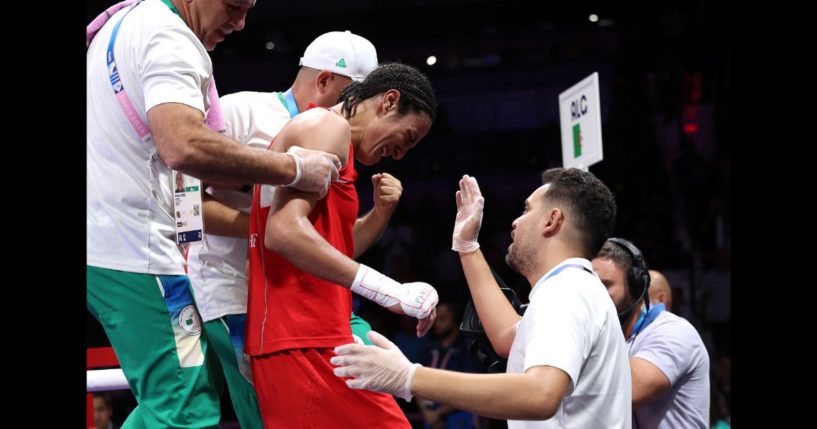 Imane Khelif of Team Algeria is assisted out of the ring by Mohamed Al-Shawa, Coach of Team Hungary after the Women's 66kg Quarter-final round match on day eight of the Olympic Games Paris 2024 at North Paris Arena on August 3, 2024 in Paris, France.