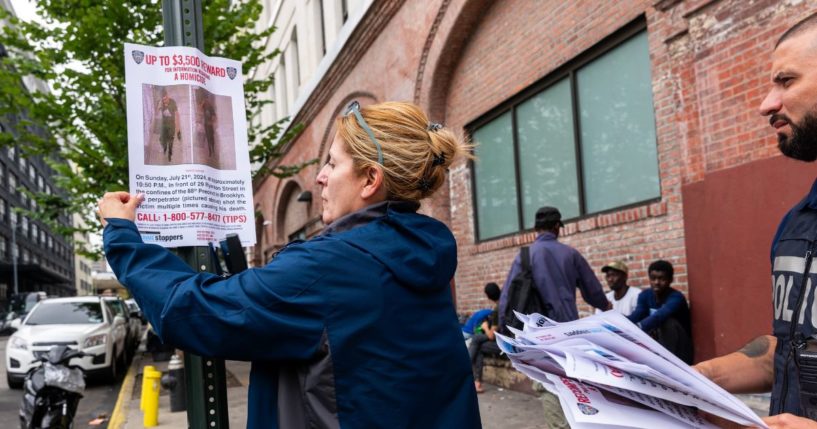 Police put up 'wanted' posters outside of two shelters in Brooklyn housing recently arrived migrant men on July 24, 2024 in New York City. Over the weekend two men were killed and a third man was hospitalized in critical condition after gunfire erupted at two separate scenes in Brooklyn near the shelters that police now believe may be related to gang violence in Venezuela.