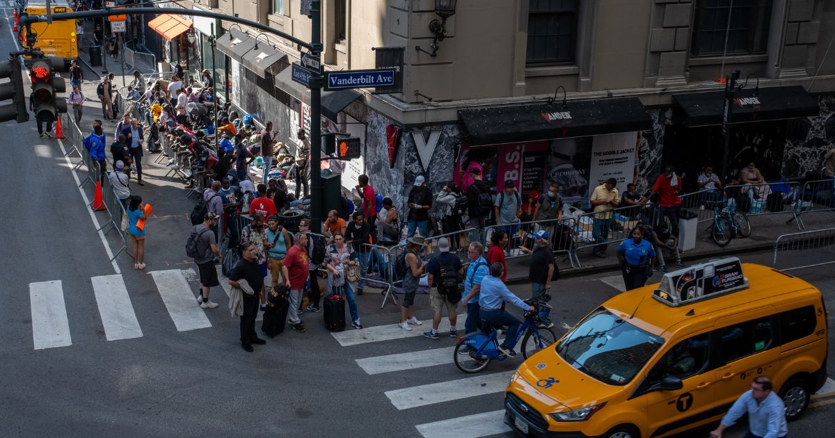 Migrants gather outside of the Roosevelt Hotel where dozens of recently arrived migrants have been camping out as they try to secure temporary housing on August 2, 2023 in New York City.