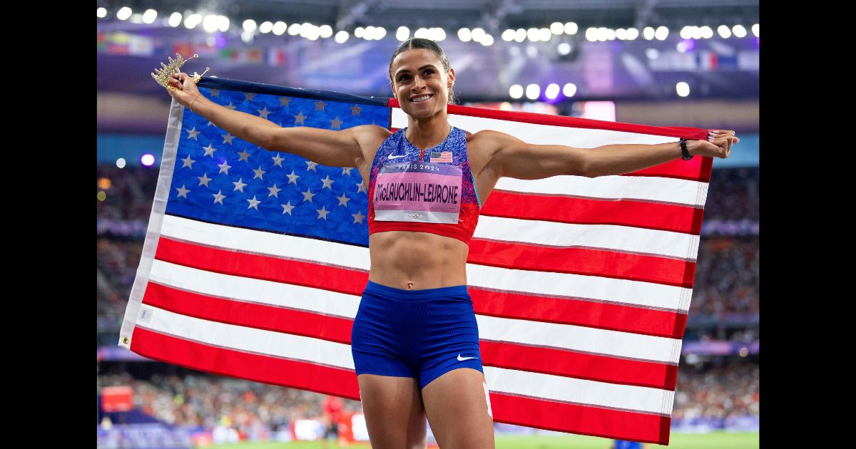 Gold medalist Sydney McLaughlin-Levrone of Team USA poses for a photo with the USA flag after the Women's 400m Hurdles Final on day thirteen of the Olympic Games Paris 2024 at Stade de France on August 8, 2024 in Paris, France.