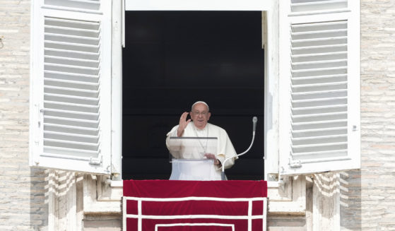 Pope Francis waves from the window of his studio overlooking St.Peter's Square during the Angelus noon prayer at the Vatican on Sunday.