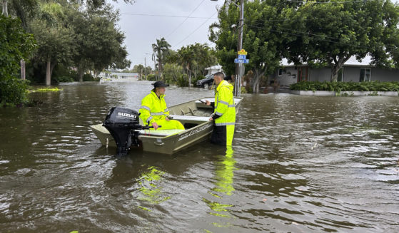 Rescue crews assist residents after conducting door-to-door wellness checks in coastal areas that were flooded by Hurricane Helene Friday in Venice, Florida .