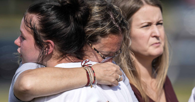 People embrace at a makeshift memorial after a shooting Wednesday at Apalachee High School on Thursday in Winder, Georgia.