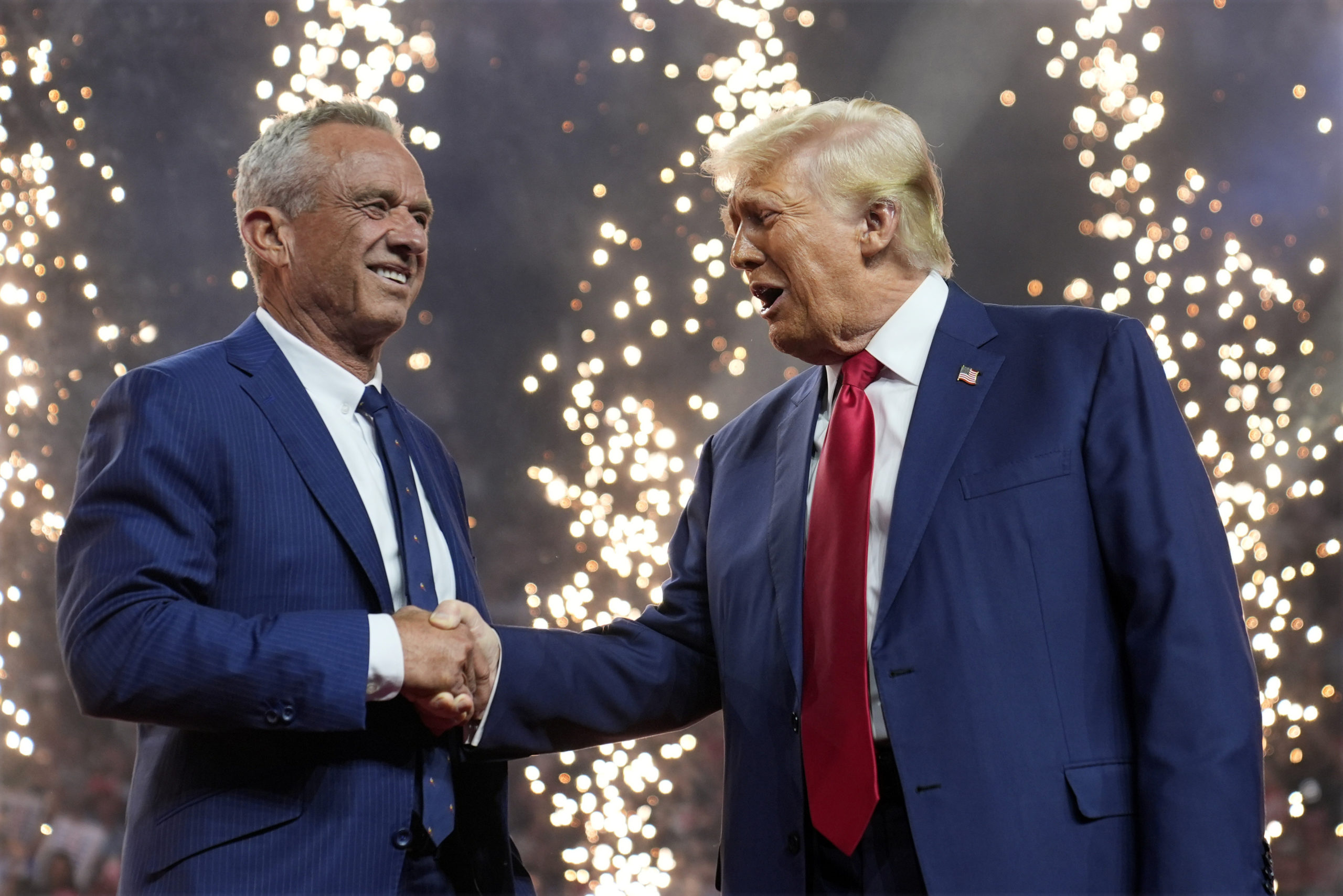 El candidato presidencial republicano Donald Trump estrecha la mano del candidato presidencial independiente Robert F. Kennedy Jr. en un acto de campaña en el Desert Diamond Arena, el viernes 23 de agosto de 2024, en Glendale, Arizona.