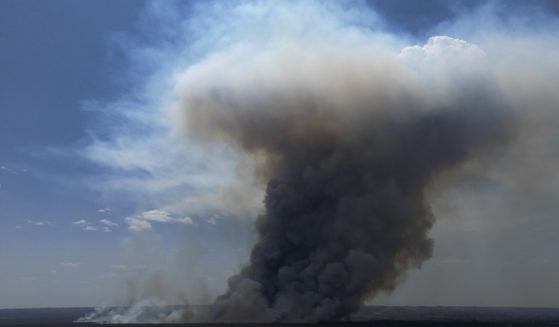 Smoke rises from fire in the environmentally protected area of Brasilia National Park during the dry season in Brasilia, Brazil on Monday. The head of the agency that manages protected areas, Mauro Pires, told the local press that the fire is man-made and appears to have started near the edge of a farm.