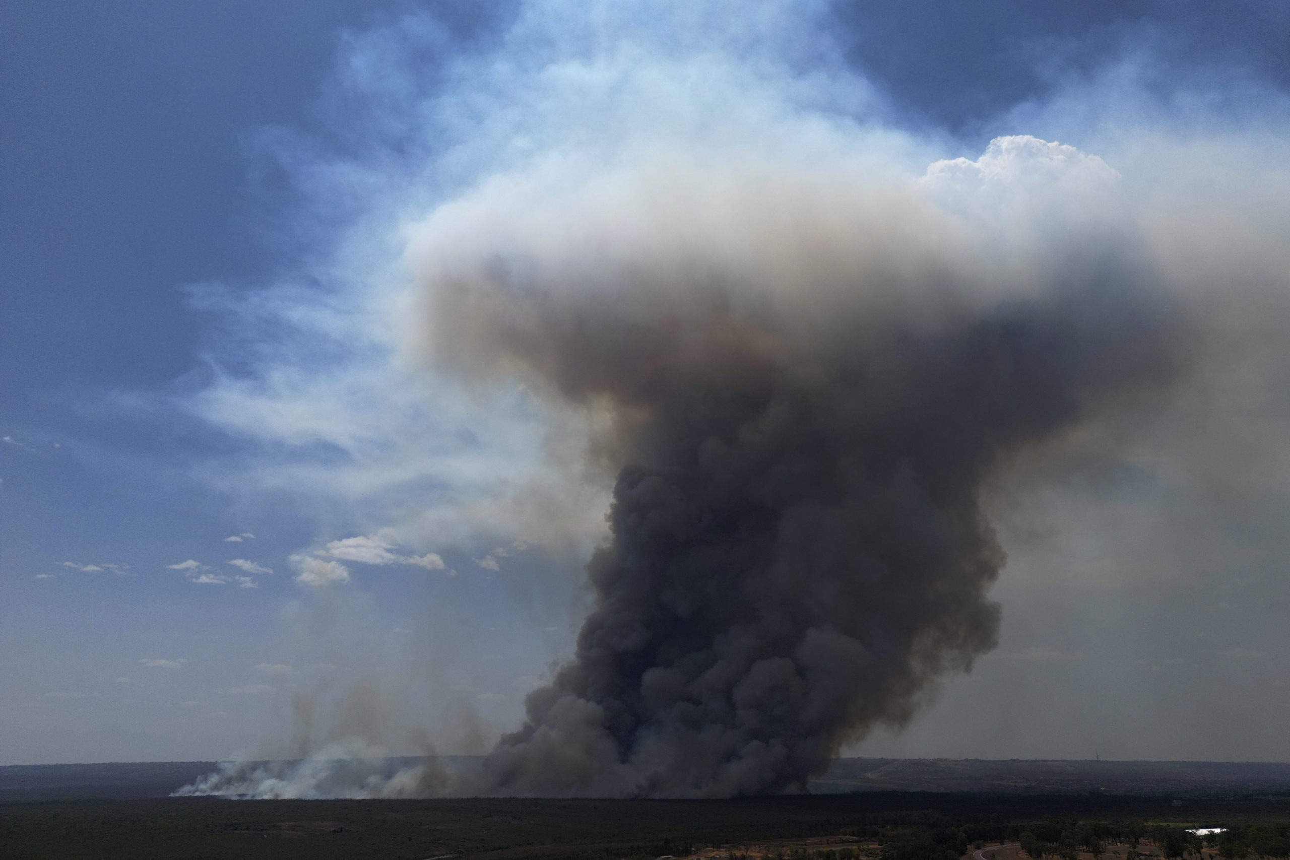 Smoke rises from fire in the environmentally protected area of Brasilia National Park during the dry season in Brasilia, Brazil on Monday. The head of the agency that manages protected areas, Mauro Pires, told the local press that the fire is man-made and appears to have started near the edge of a farm.