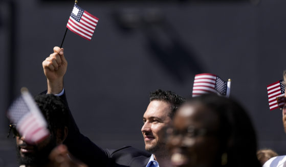 A man, part of a group of 50 new United States citizens from 25 different countries, takes part in a naturalization ceremony before the San Diego Padres host the Minnesota Twins in a baseball game in San Diego on Aug. 21.