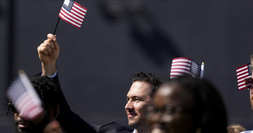 A man, part of a group of 50 new United States citizens from 25 different countries, takes part in a naturalization ceremony before the San Diego Padres host the Minnesota Twins in a baseball game in San Diego on Aug. 21.