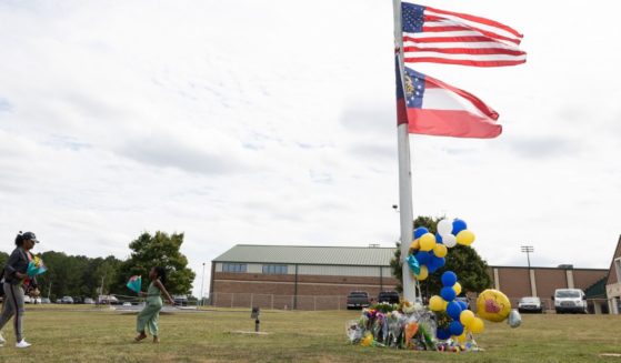 Community members visit a makeshift memorial at Apalachee High School Thursday in Winder, Georgia. Two students and two teachers were shot and killed at the school Wednesday. A 14-year-old suspect, who is a student at the school, is in custody.