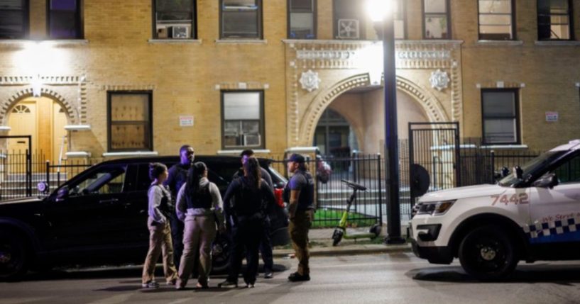 Police gather outside an apartment building in Chicago, Illinois, on Monday after receiving 9-1-1 calls concerning an illegal immigrant takeover at the residence.