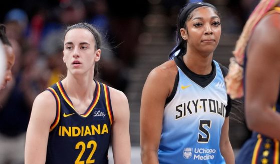 Rookies Caitlin Clark of the Indiana Fever, left, and Angel Reese of the Chicago Sky, right, look on during a game in Indianapolis, Indiana, on June 16.