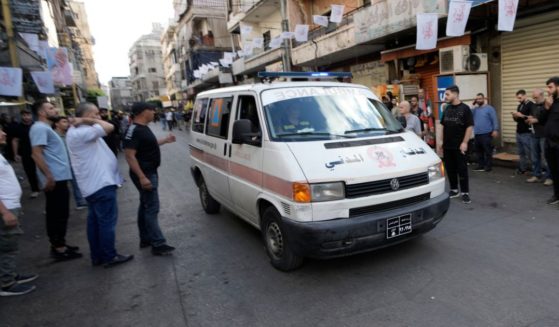 An ambulance, believed to be carrying wounded Hezbollah members, drives through Beirut, Lebanon, on Wednesday, following multiple explosions at a funeral for four Hezbollah fighters who were killed Tuesday.