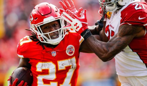 Kareem Hunt of the Kansas City Chiefs, left, tries to fight off a tackle from Patrick Peterson of the Arizona Cardinals, right, during the first half of the game at Arrowhead Stadium in Kansas City, Missouri, Nov. 11, 2018.