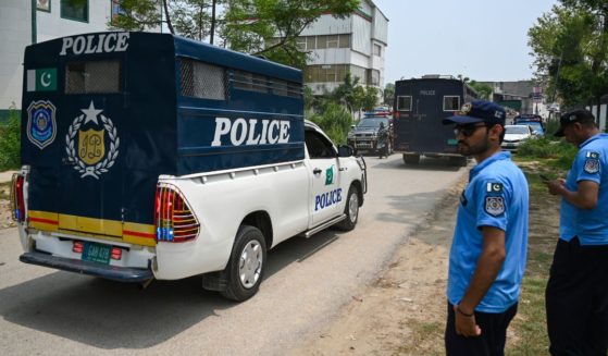 Police in Pakistan make way for a police van after a security raid at the Pakistan Tehreek-e-Insaf party's headquarters in Islamabad on July 22.