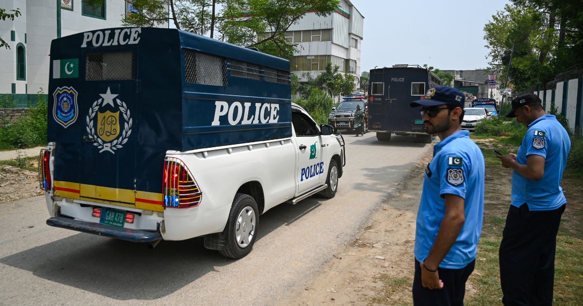 Police in Pakistan make way for a police van after a security raid at the Pakistan Tehreek-e-Insaf party's headquarters in Islamabad on July 22.