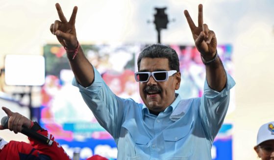 Incumbent President of Venezuela Nicolas Maduro raises his arms and make a “v” with his hands during the 'Gran Marcha Mundial por la Paz' supporting Maduro on August 17, 2024 in Caracas, Venezuela.