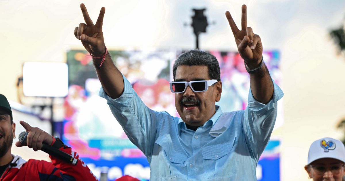 Incumbent President of Venezuela Nicolas Maduro raises his arms and make a “v” with his hands during the 'Gran Marcha Mundial por la Paz' supporting Maduro on August 17, 2024 in Caracas, Venezuela.