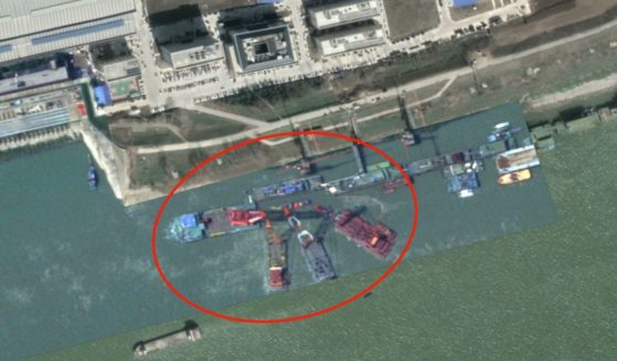 A defense analyst posted photos of crane barges surrounding a "submarine-shaped" object under the water.