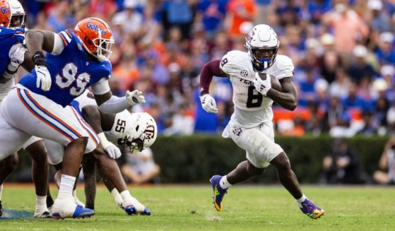 Le'Veon Moss, right, of the Texas A&M Aggies runs with the ball during the first half of a game against the Florida Gators in Gainesville, Florida, on Saturday.