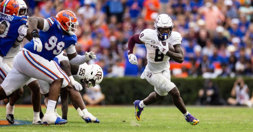 Le'Veon Moss, right, of the Texas A&M Aggies runs with the ball during the first half of a game against the Florida Gators in Gainesville, Florida, on Saturday.