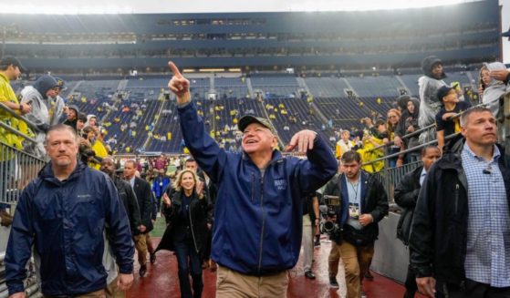 Democratic vice presidential candidate and Minnesota Gov. Tim Walz arrives before the game between the University of Minnesota and University of Michigan in Ann Arbor, Michigan, on Saturday.