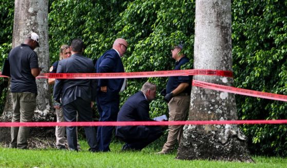 Law enforcement officials work at the crime scene outside the Trump International Golf Club in West Palm Beach, Florida, on Monday.