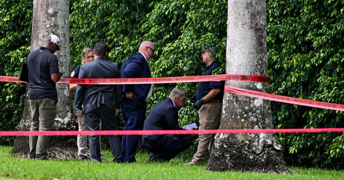 Law enforcement officials work at the crime scene outside the Trump International Golf Club in West Palm Beach, Florida, on Monday.