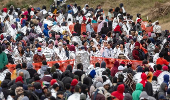 Immigrants wait to be processed at a U.S. Border Patrol transit center after they crossed the border from Mexico on December 20, 2023 in Eagle Pass, Texas. A late-year surge of migrants crossing the U.S.southern border has overwhelmed U.S. immigration officials.