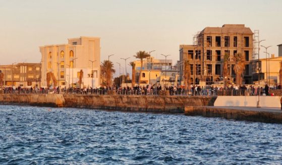 People walk at the seaside promenade in the Gargaresh district of the Libyan capital Tripoli on January 26, 2024.