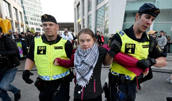 Swedish climate activist Greta Thunberg (C) wearing the keffiyeh scarf is removed by police during a pro-Palestinian demonstration outside the Malmo Arena venue ahead of the final of the 68th Eurovision Song Contest (ESC) 2024 on May 11, 2024 in Malmo, Sweden.