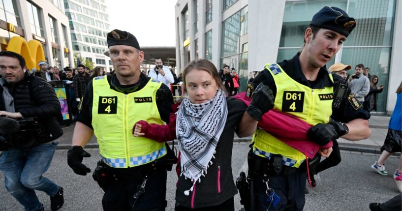 Swedish climate activist Greta Thunberg (C) wearing the keffiyeh scarf is removed by police during a pro-Palestinian demonstration outside the Malmo Arena venue ahead of the final of the 68th Eurovision Song Contest (ESC) 2024 on May 11, 2024 in Malmo, Sweden.