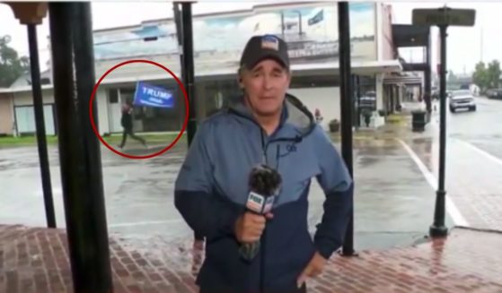 During a Fox News weather report in Morgan City, Louisiana, a supporter of former President Donald Trump, circled, ran behind the reporter with a Trump flag, prompting him to cover the screen.