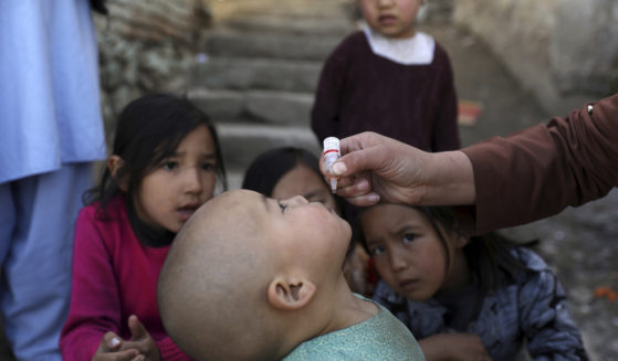 Shabana Maani, gives a polio vaccination to a child in the old part of Kabul, Afghanistan, Monday, March 29, 2021.