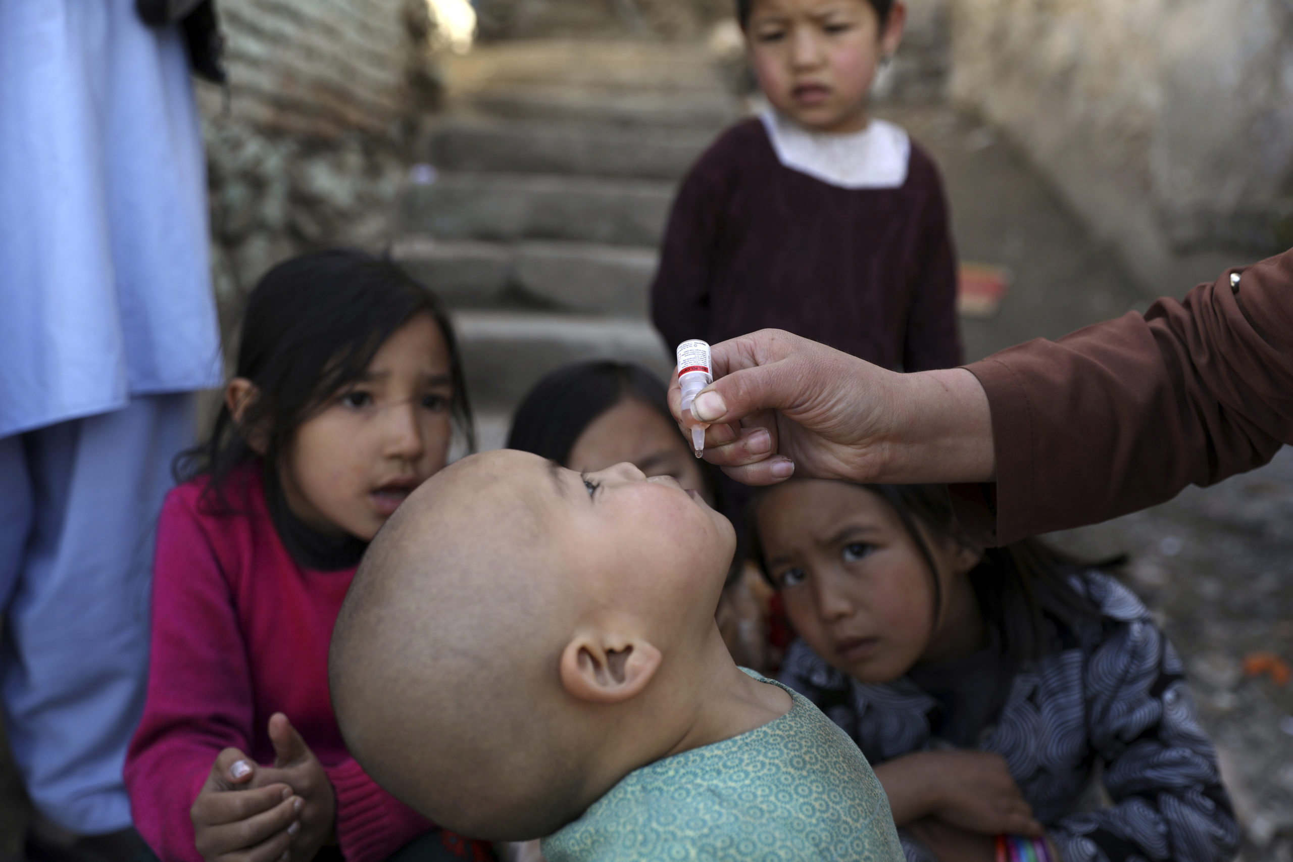 Shabana Maani, gives a polio vaccination to a child in the old part of Kabul, Afghanistan, Monday, March 29, 2021.