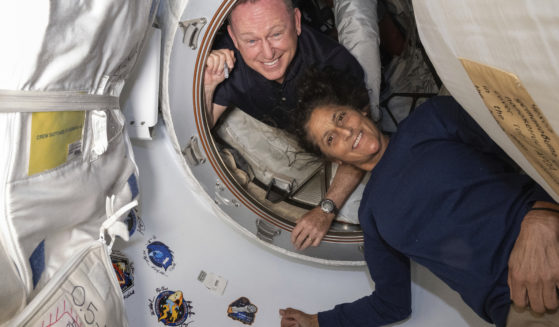 Boeing Crew Flight Test astronauts Butch Wilmore, left, and Suni Williams pose for a June 13 portrait inside the vestibule between the forward port on the International Space Station's Harmony module and Boeing's Starliner spacecraft.