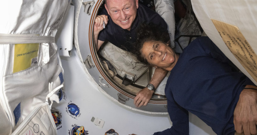 Boeing Crew Flight Test astronauts Butch Wilmore, left, and Suni Williams pose for a June 13 portrait inside the vestibule between the forward port on the International Space Station's Harmony module and Boeing's Starliner spacecraft.