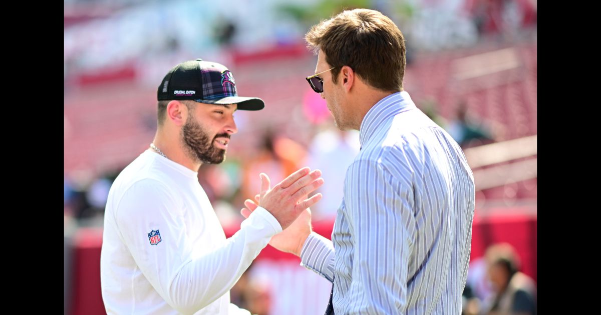 Baker Mayfield #6 of the Tampa Bay Buccaneers and former NFL player Tom Brady embrace prior to a game against the Philadelphia Eagles at Raymond James Stadium on September 29, 2024 in Tampa, Florida.