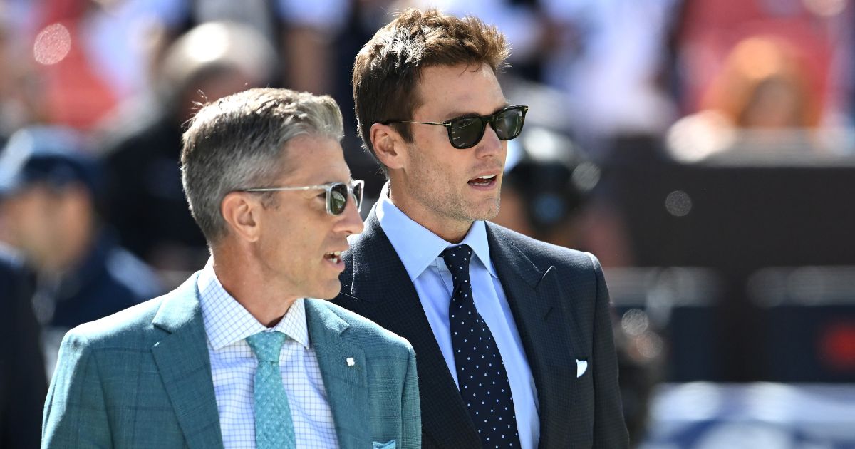 Broadcasters Kevin Burkhardt (L) and Tom Brady (R) walk along the field before the game between the Dallas Cowboys and Cleveland Browns at Cleveland Browns Stadium on September 8, 2024 in Cleveland, Ohio.