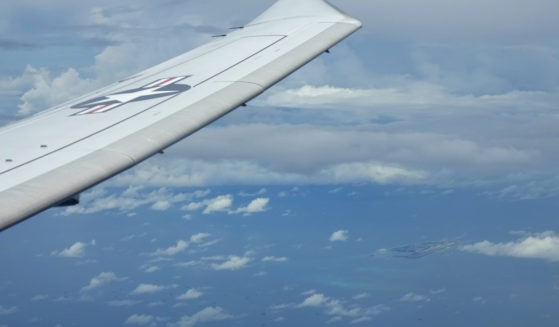 A U.S. P-8A Poseidon reconnaissance plane flies near Chinese structures and buildings on the man-made Fiery Cross Reef at the Spratlys group of islands in the South China Sea are seen on March 20, 2022.